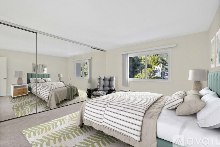 A bedroom with two beds and a large mirror on the wall.
