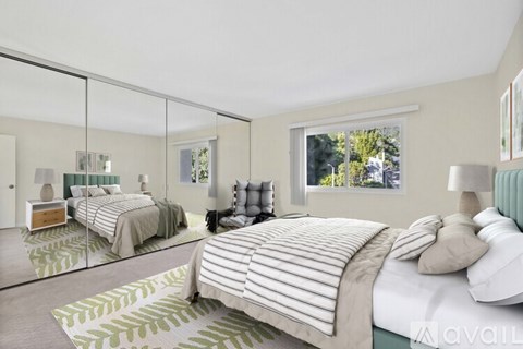 A bedroom with two beds and a large mirror on the wall.