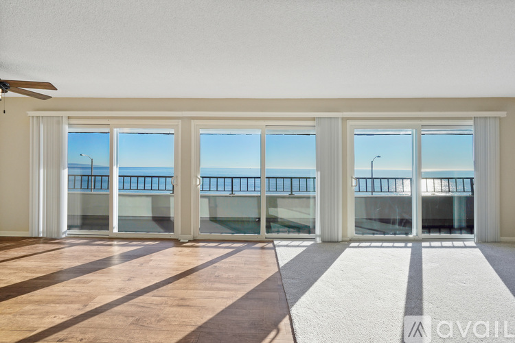 A spacious room with a balcony overlooking the ocean.