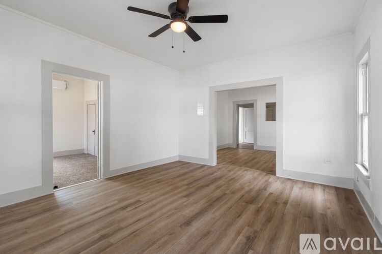 A room with wooden floors and a ceiling fan.