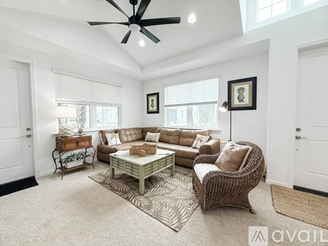 A living room with a sofa set, a coffee table, and a ceiling fan.