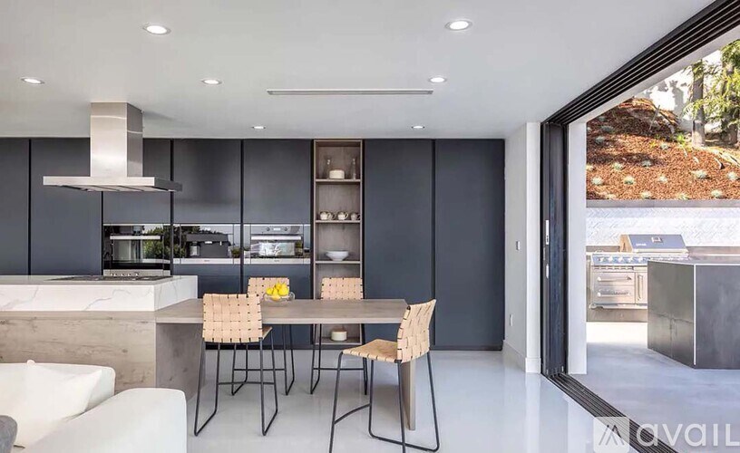 A modern kitchen with a dining table set for two.