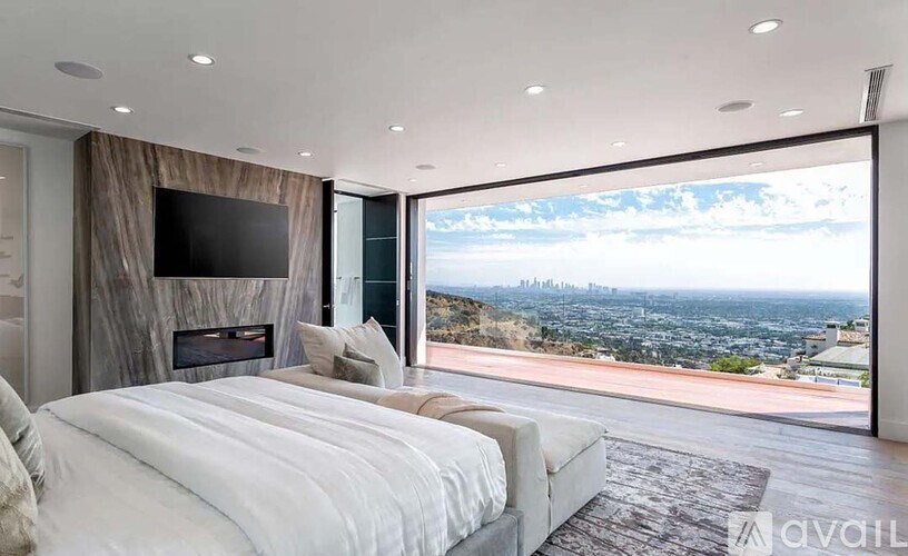 A bedroom with a large bed and a view of the city.