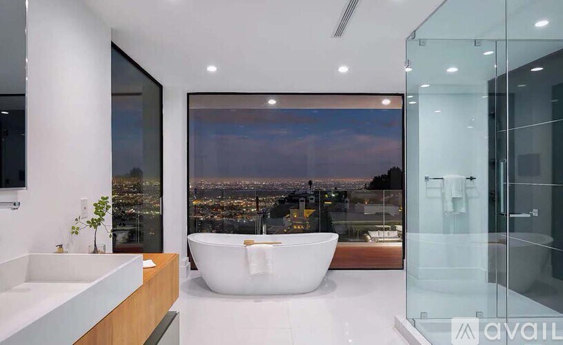 A modern bathroom with a large window overlooking a cityscape.