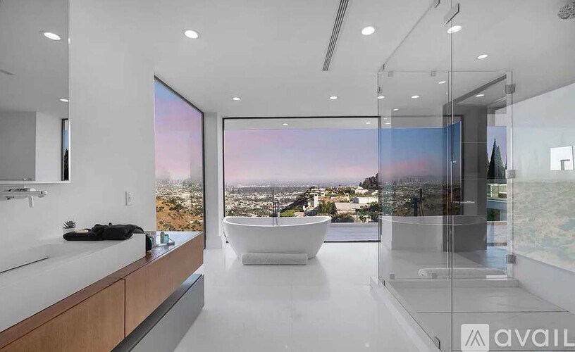 A modern bathroom with a large window overlooking a cityscape.