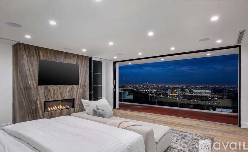 A bedroom with a large bed and a view of the city.