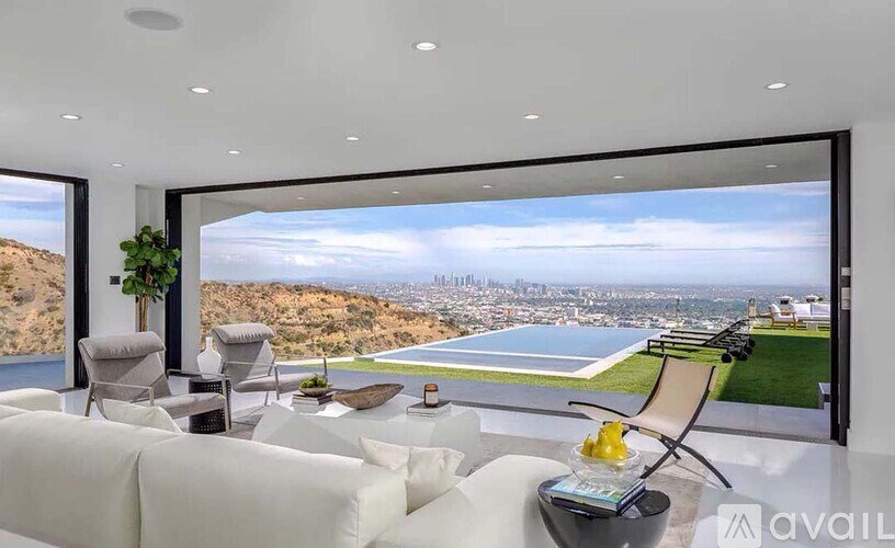 A modern living room with a view of the cityscape outside the large window.