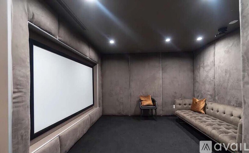 A modern home theater with a couch and a large screen.