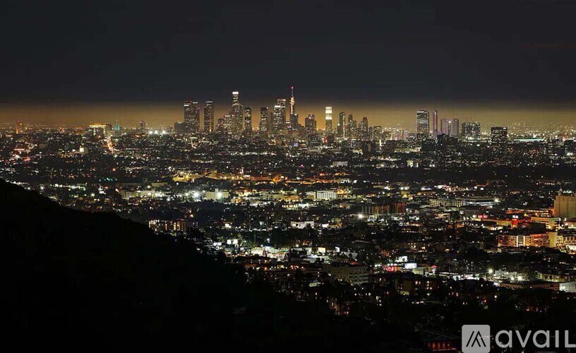 A cityscape at night with a mountain in the foreground.
