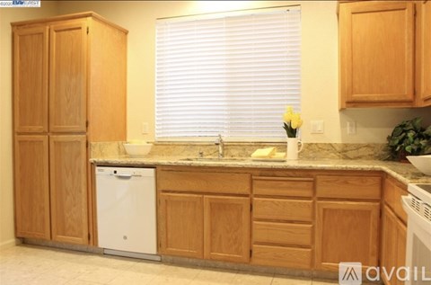 A kitchen with wooden cabinets and a white dishwasher.