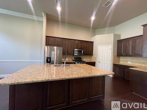 A kitchen with brown cabinets and a granite countertop.