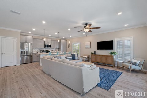 A spacious living room with a white couch and a ceiling fan.