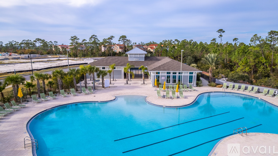 A large outdoor swimming pool surrounded by lounge chairs and umbrellas.