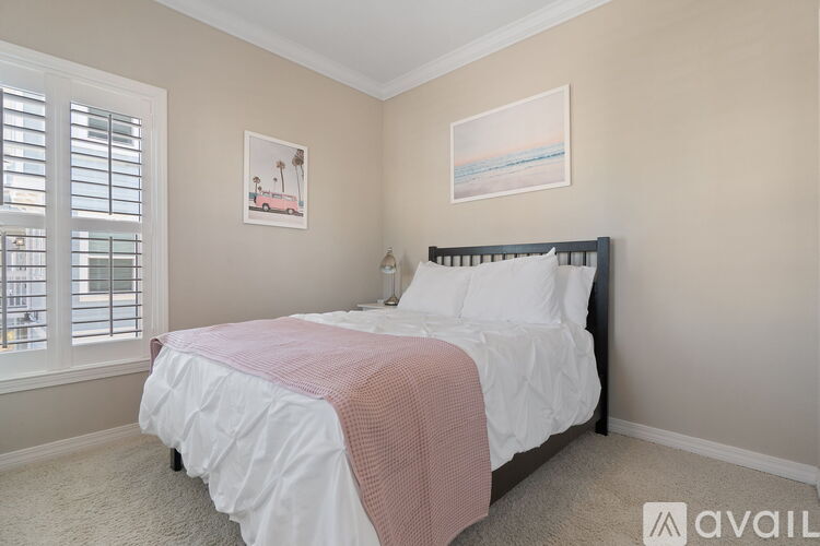 A bedroom with a large bed and a window with shutters.