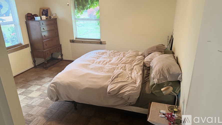 A bedroom with a bed, dresser, and window.