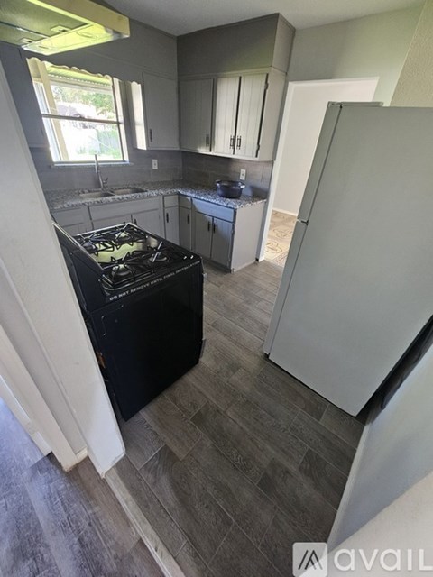 A kitchen with a black stove top oven and a white refrigerator.
