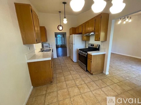 A kitchen with wooden cabinets and a tiled floor.
