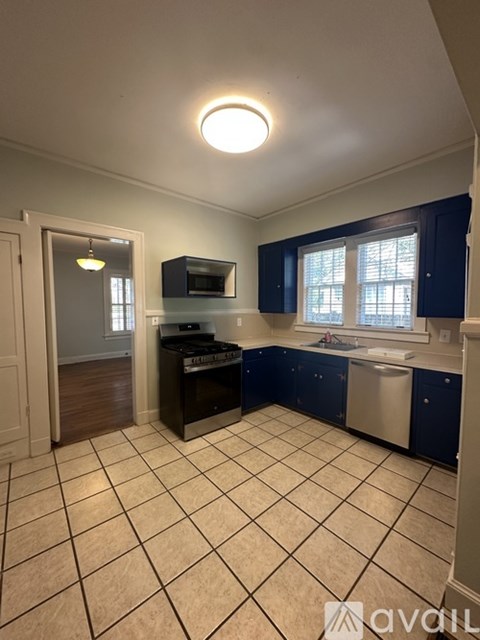 A kitchen with blue cabinets and a white tile floor.