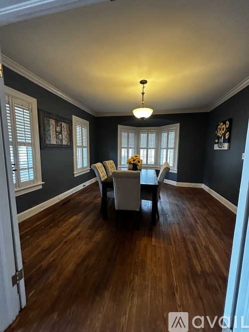 A room with wooden floors and a table with chairs.