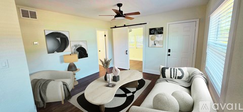 A living room with a white couch and a ceiling fan.