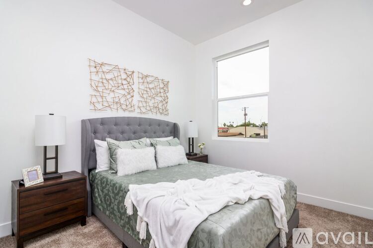 A bedroom with a bed, nightstand, and lamp.