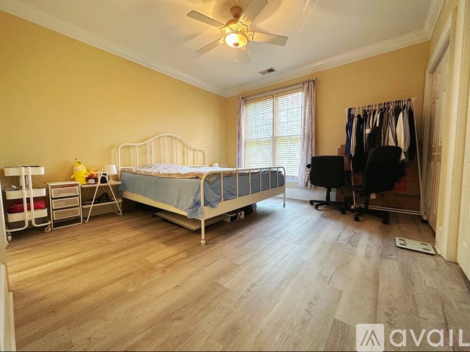 A bedroom with a bed, a chair, and a clothing rack.