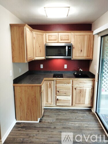 A kitchen with wooden cabinets and a black countertop.