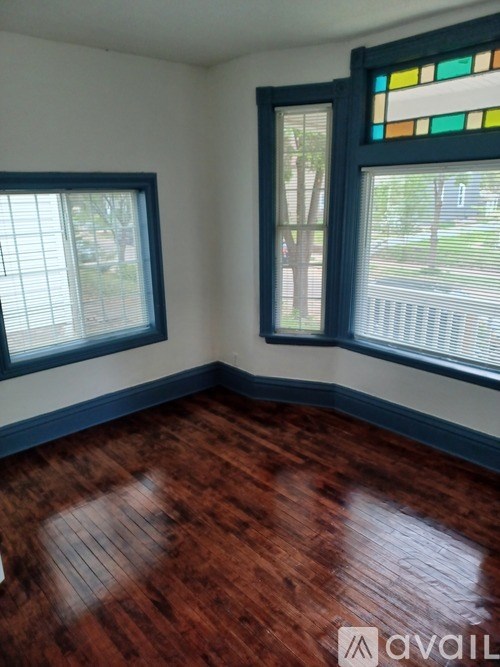A room with wooden floors and two windows.