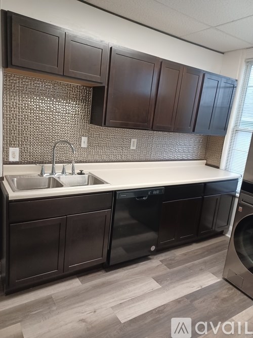 A kitchen with dark brown cabinets and a white countertop.