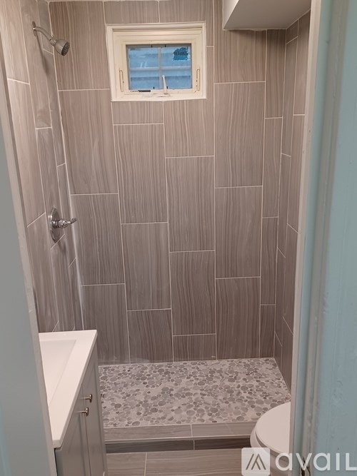 A bathroom with a shower and a window.