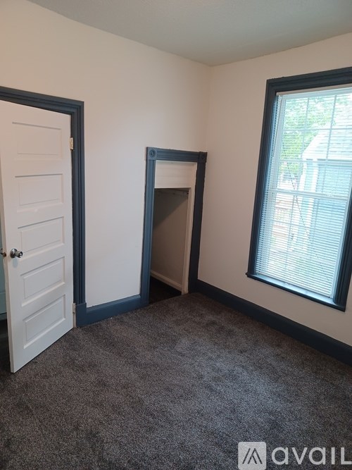 A room with a door, a window, and a fireplace.