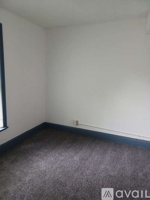 A room with a carpeted floor and a window.