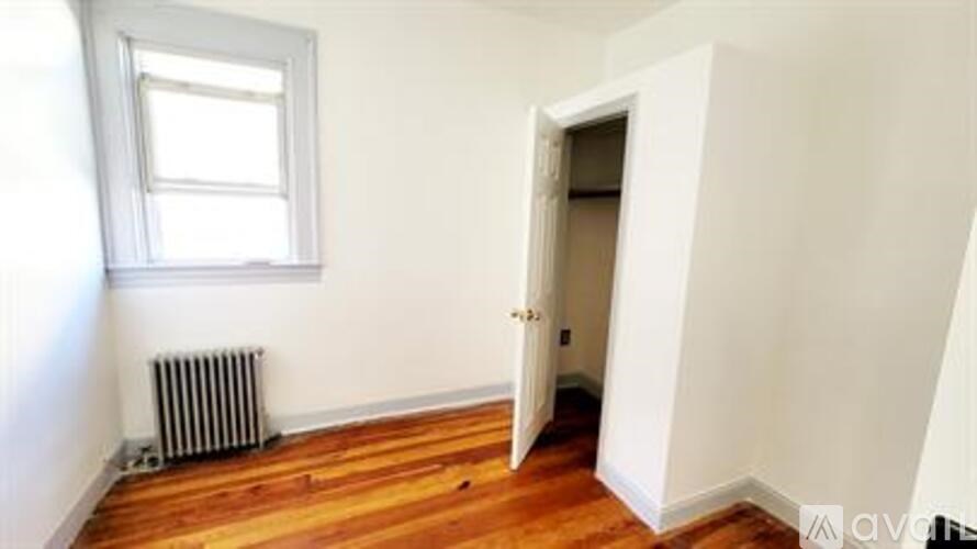 A room with a wooden floor and a window.