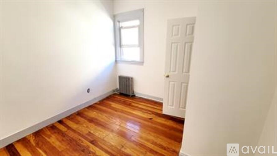 A room with wooden floors and a window.
