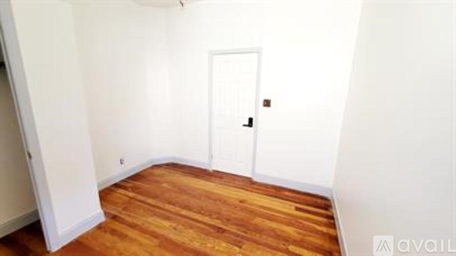 A room with a wooden floor and a white door.