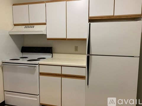 A white kitchen with a stove and refrigerator.