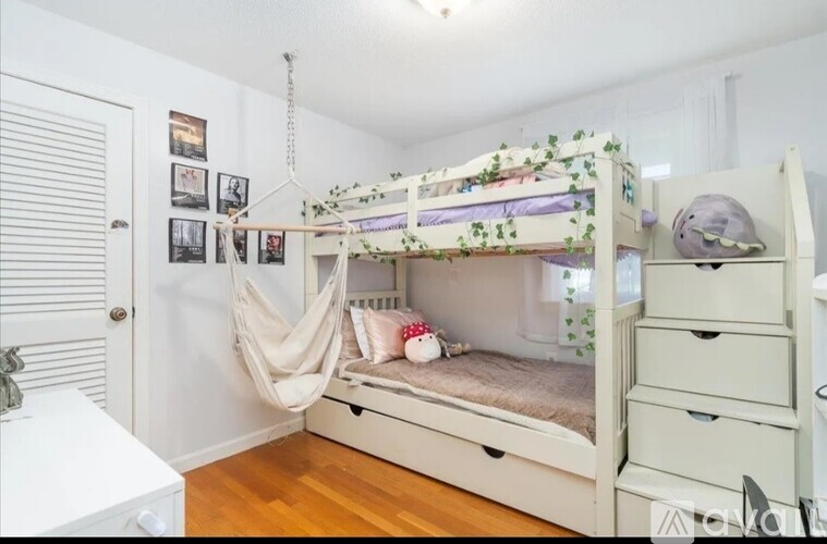 A white bunk bed with a canopy and drawers underneath.