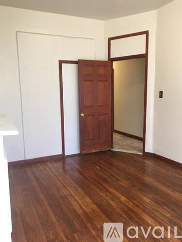 A room with a wooden floor and a brown door.