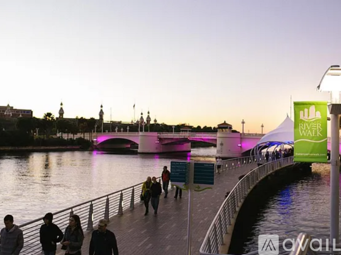 A group of people are walking on a bridge over a body of water.