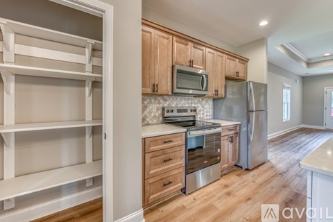 A kitchen with wooden cabinets and a stainless steel refrigerator.
