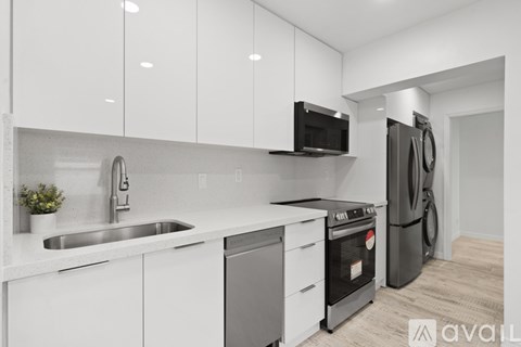 A modern kitchen with white cabinets and stainless steel appliances.