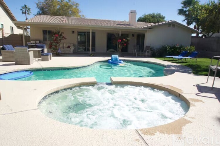 A hot tub sits in the middle of a pool in a backyard.