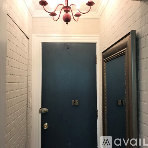 A bathroom with a blue door and a mirror.