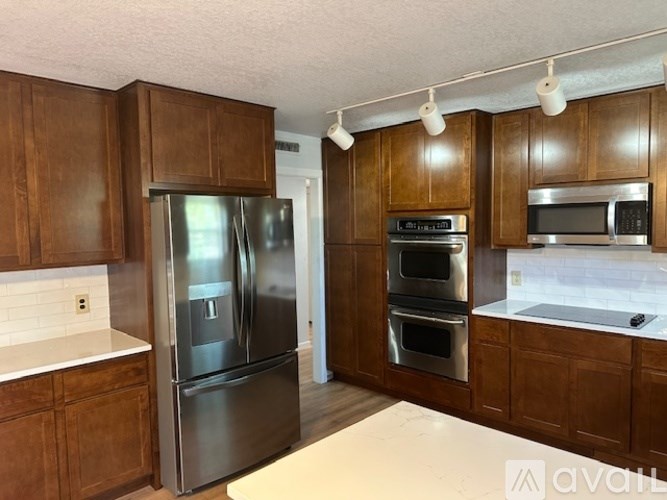 A kitchen with wooden cabinets and stainless steel appliances.