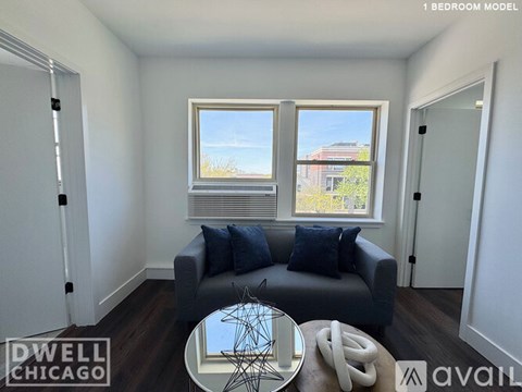 A living room with a grey couch and a glass table.