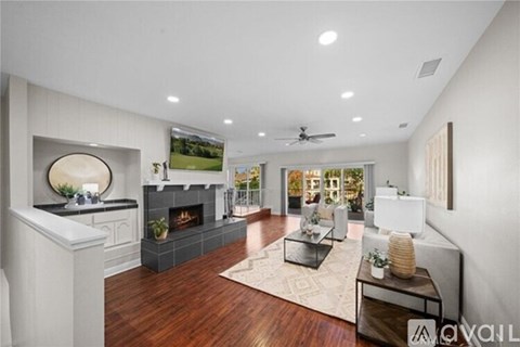 A modern living room with a fireplace and a painting on the wall.