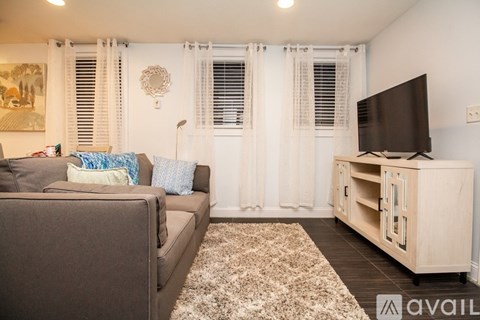 A living room with a brown couch and a white cabinet.