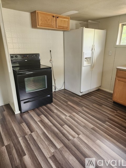 A kitchen with a black oven and white fridge.
