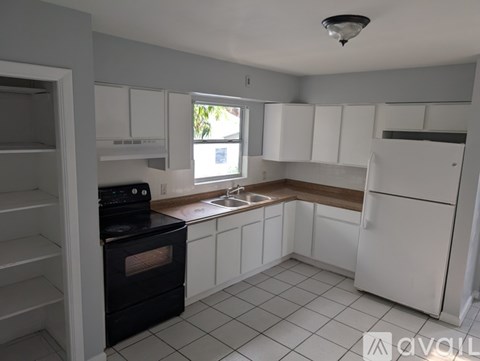 A kitchen with white cabinets and a black oven.