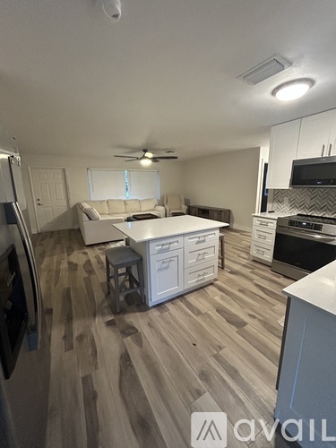 A kitchen with a refrigerator, a stove, and a dining table.